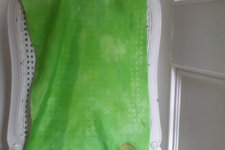 Lime green scarf with gold detail displayed on chair